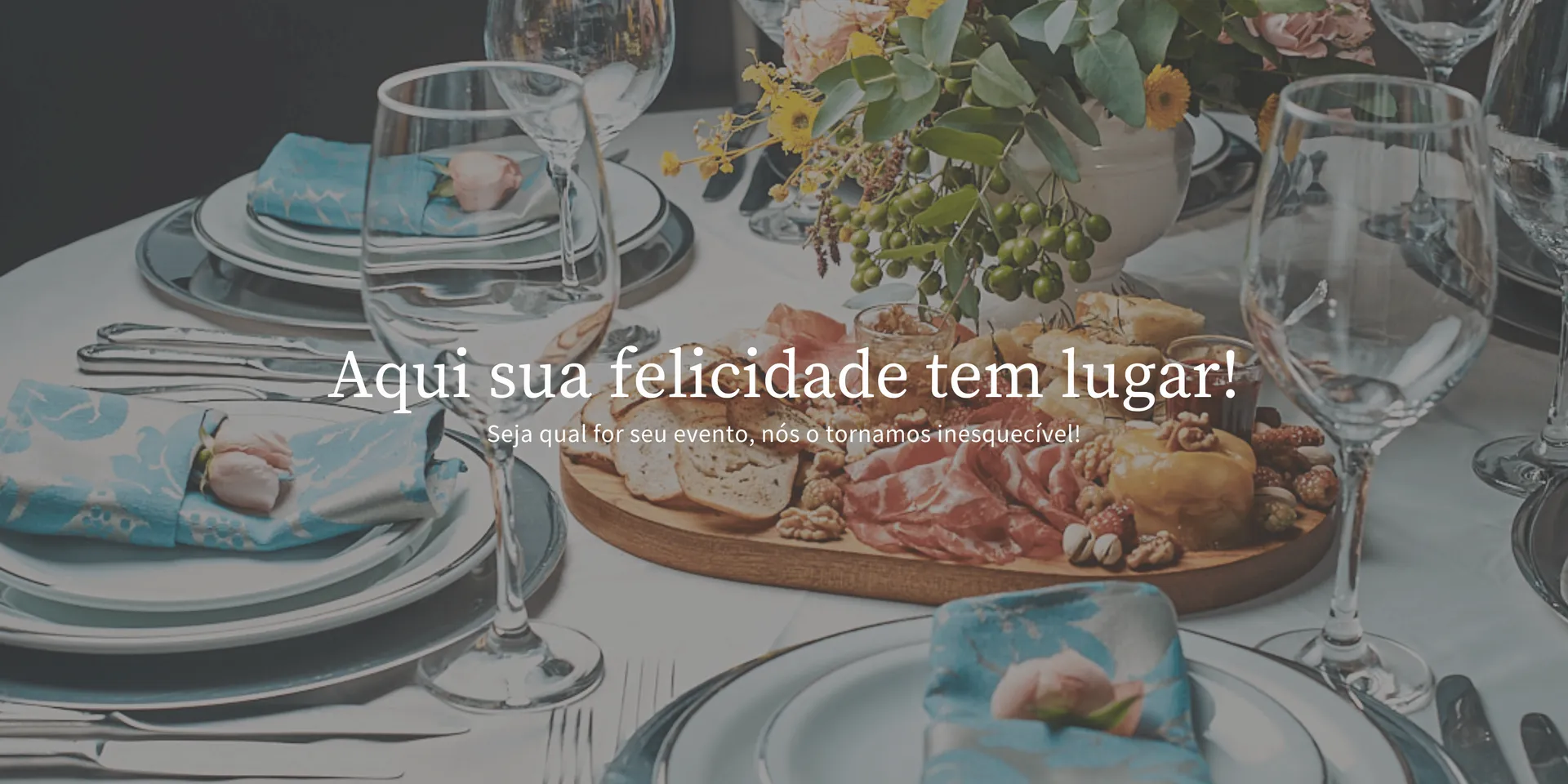 Uma mesa posta com pratos, taças de vinho e uma tábua de cortar.